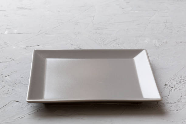 istock Perspective view of empty square plate on cement background. Empty space for your design 1371927254