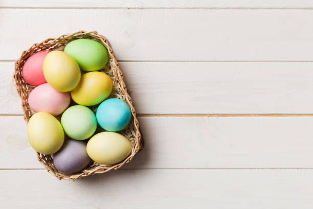 istock Multi colors Easter eggs in the woven basket on colored background . Pastel color Easter eggs. holiday concept with copy space 1371927255