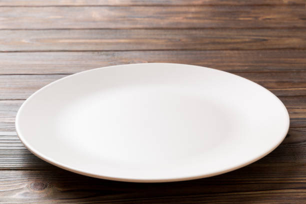 istock Perspective view of empty light plate on wooden background. Empty space for your design 1371927256