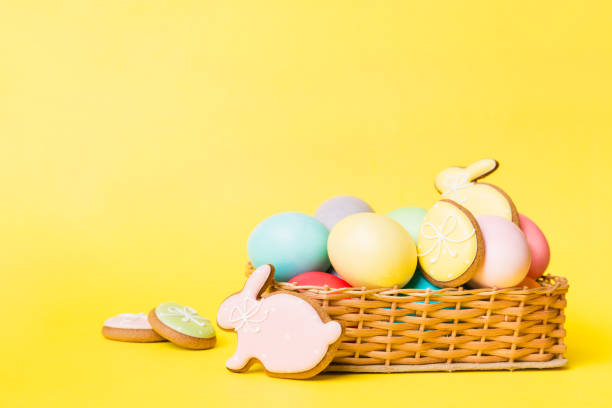 istock Colorful easter cookies in basket with Multi colors Easter eggs on colored background . Pastel color Easter eggs. holiday concept with copy space 1371927268
