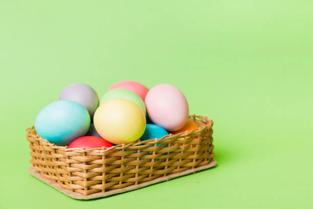 istock Multi colors Easter eggs in the woven basket on colored background . Pastel color Easter eggs. holiday concept with copy space 1371927276