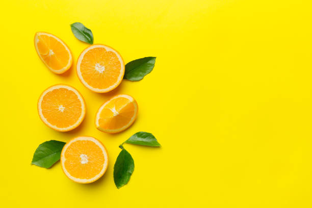 istock fresh Fruit orange slices on colored background. Top view. Copy Space. creative summer concept. Half of citrus in minimal flat lay with copy space 1371927821