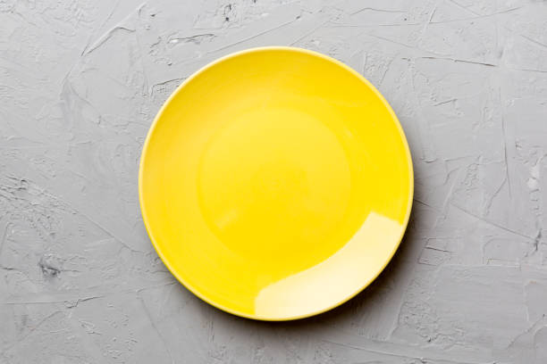 istock Top view of empty yellow plate on cement background. Empty space for your design 1371927924