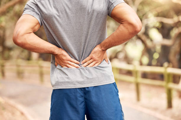 自然の中でワークアウト中に腰痛を経験している認識できない男のショット - back rear view backache posture ストックフォトと画像