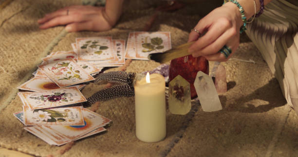 Meditative space in desert tent. Serene woman smudging with palo santo. Soul journey with divination cards stock photo
