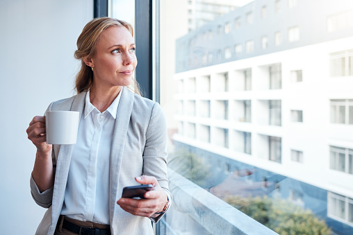 Positive inspired confident millennial lady in suit enjoy work in city outdoors, with crossed arms near office building, look at empty space. Business startup, lifestyle, ad and offer