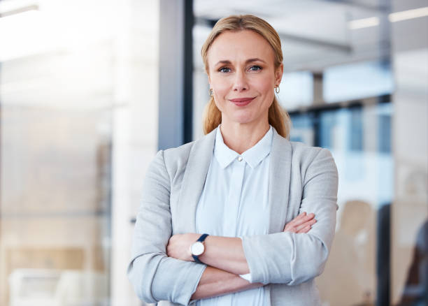 portrait d’une femme d’affaires mature confiante travaillant dans un bureau moderne - female photos et images de collection