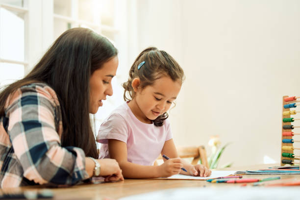 przycięte ujęcie uroczej dziewczynki odrabiającej lekcje z pomocą mamy - homework child mother parent zdjęcia i obrazy z banku zdjęć