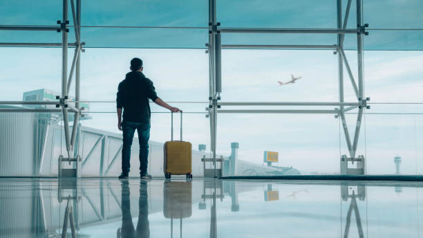 Passenger with baggage at international airport walking to terminal gate - Travel and transportation concept stock photo