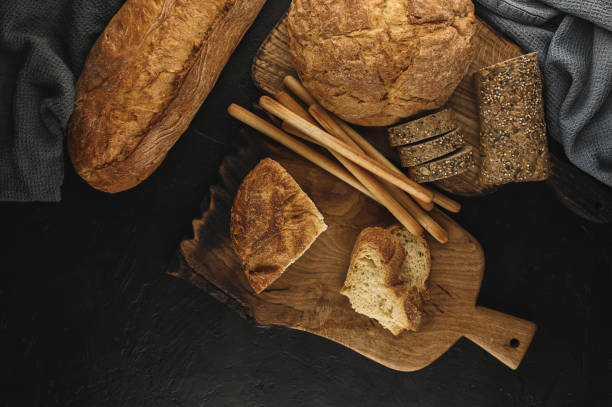 istock rural rustic types of bread on a black table. 1371940025