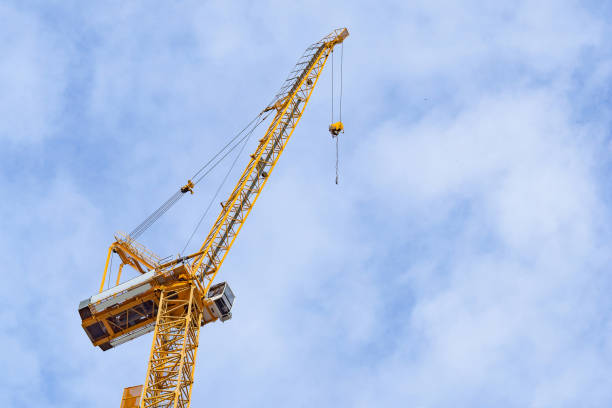 istock Yellow construction crane against clouds and sky background 1371940060