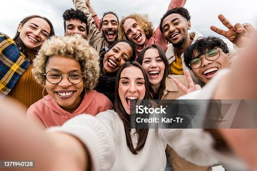 istock Multiracial friends taking big group selfie shot smiling at camera - Laughing young people standing outdoor and having fun - Cheerful students portrait outside school - Human resources concept 1371940128
