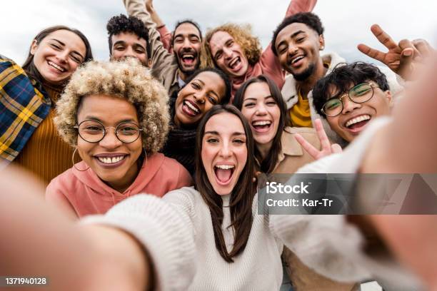 Multiracial Friends Taking Big Group Selfie Shot Smiling At Camera Laughing Young People Standing Outdoor And Having Fun Cheerful Students Portrait Outside School Human Resources Concept Stock Photo - Download Image Now