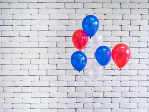 Colorful balloons against a white brick wall