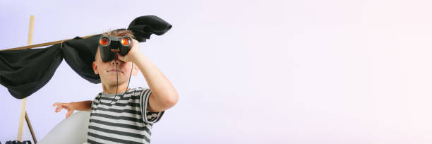 istock Little child boy playing with cardboard ship on blue wall background 1371941457