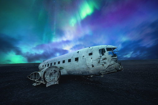 Plane wreck on the black beach at Solheimasandur, in the south coast of Iceland under the northern lights.