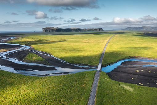 Aerial view on a road crossing the glacial river in South Iceland. View on Hjorleifshofdi in the background.