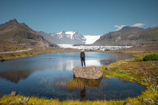 Hiker man with in the mountains. Mountain with glacier and tourist