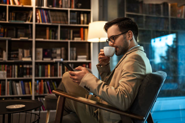 istock Businessman text messaging on smart phone and drinking coffee 1371945873