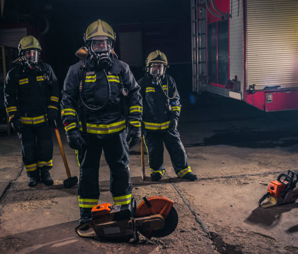 istock Group of three young fireman posing inside the fire department with uniform and tools 1371946946