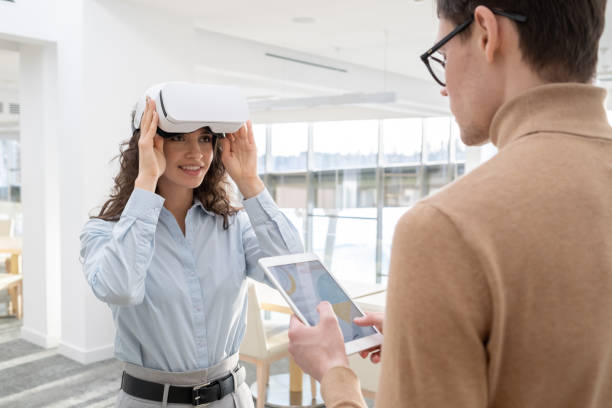 istock Happy young employee touching vr headset while communicating with male colleague 1371947010