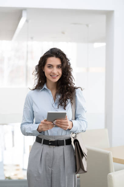 istock Young gorgeous female entrepreneur with tablet standing in modern office 1371947068