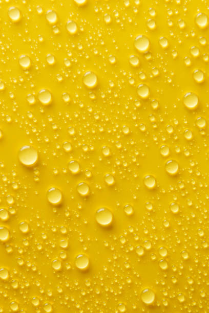 istock Drops of water on a yellow background. 1371947295