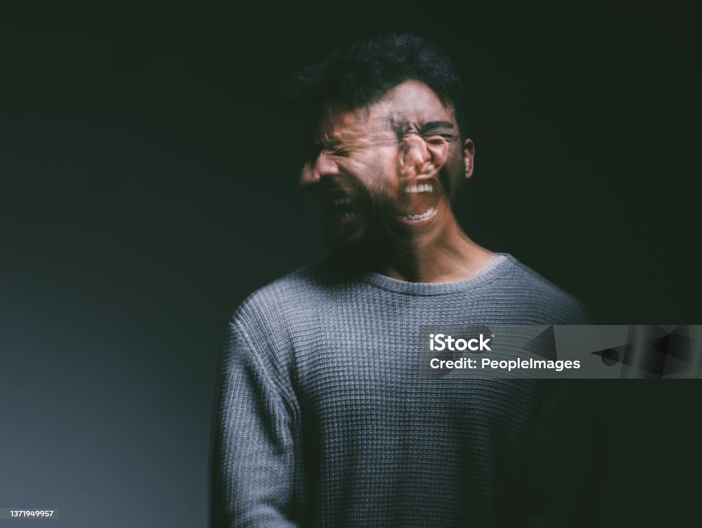 Studio shot of a young man experiencing mental anguish and screaming against a black background Your thoughts can make you or break you Insanity Stock Photo