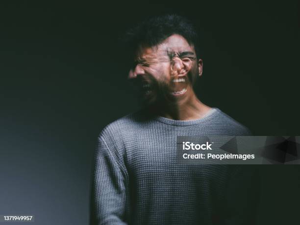 Studio Shot Of A Young Man Experiencing Mental Anguish And Screaming Against A Black Background Stock Photo - Download Image Now