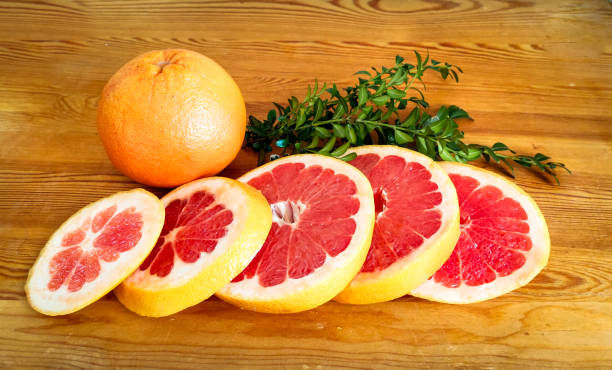 Citrus grapefruit slices on wooden background stock photo