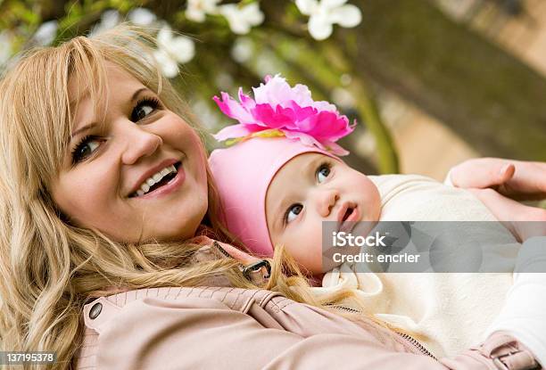 Jovem Mãe Com Seu Bebê Menina Em Um Jardim - Fotografias de stock e mais imagens de Abril - Abril, Adulto, Ao Ar Livre