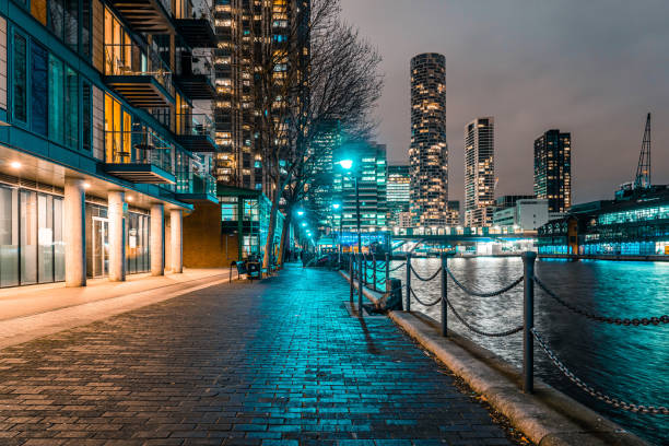 canary wharf, moderno distrito financiero y residencial de londres. rascacielos y reflexión de la luz en el agua del muelle - east london fotografías e imágenes de stock