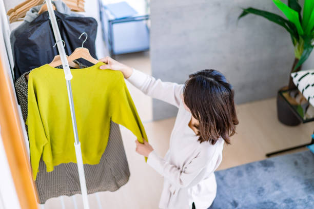 Young woman choosing clothes at home