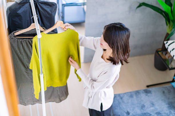 istock Young woman choosing clothes at home 1371954237