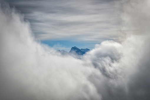 Alpine peak hiding behind the clouds as seen from Fronalpstock peak in canton of Schywz in Switzerland