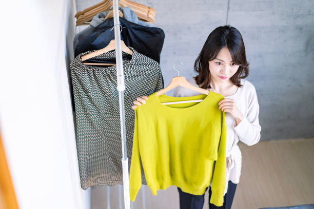 istock Young woman choosing clothes at home 1371954245