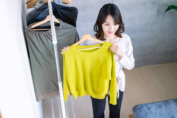 istock Young woman choosing clothes at home 1371954254