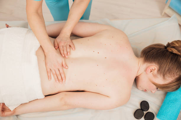 istock massage therapist therapeutic back massage for woman in spa 1371955836