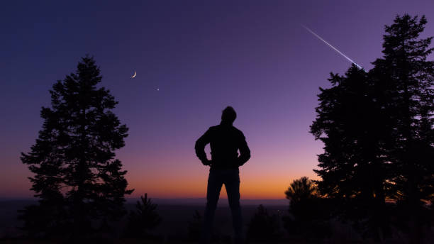 istock Man observing evening sky with stars, planets and crescent Moon. 1371956241
