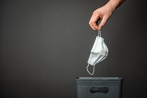 The medical mask is thrown into the trash for recycling and recycling