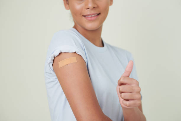 istock Girl showing thumb up after vaccination 1371958801