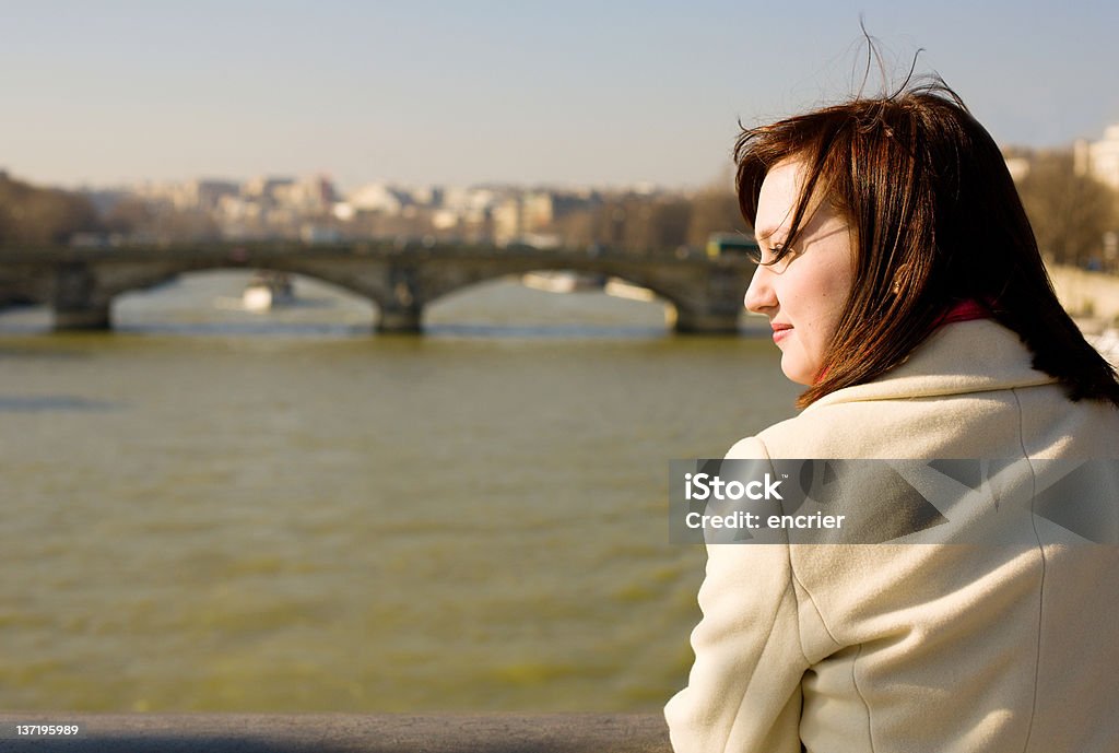 Beautiful woman in Paris on the Seine embankment, contemplating Beautiful woman in Paris on the Seine embankment, contemplating the river, thoughtful Adult Stock Photo
