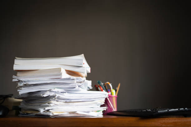 a pile of paper sheets and books on a table - book school desk old imagens e fotografias de stock