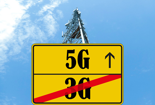 Illustration of the end of life for 3rd generation or 3G cell mobile networks and replacement with 5G. Road sign with 3G and 5G text against rural cellphone tower