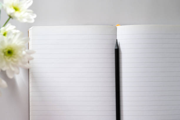istock Open notebook, empty pages with cup of coffee, table top. Spring flowers. 1371963250