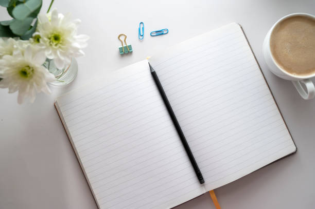 istock Open notebook, empty pages with cup of coffee, table top. Spring flowers. 1371963354