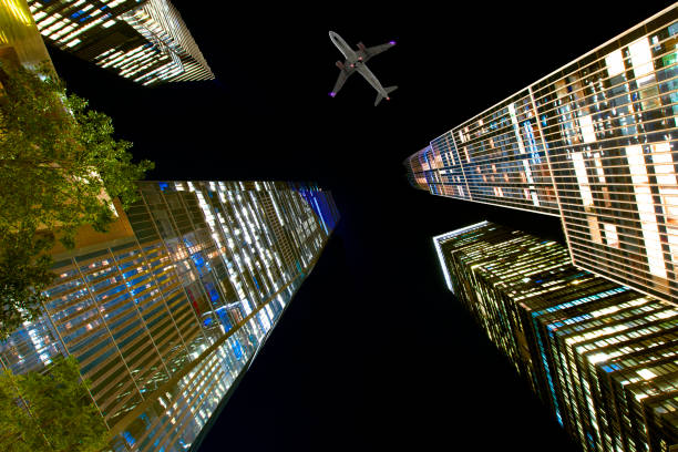 istock Airplane flying over skyscrapers at night. 1371965207