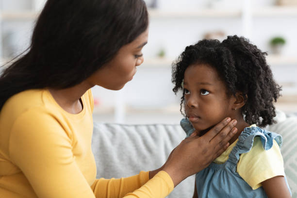 mãe negra cuidando de seu filho doente sofrendo de dor de garganta - tonsillitis - fotografias e filmes do acervo