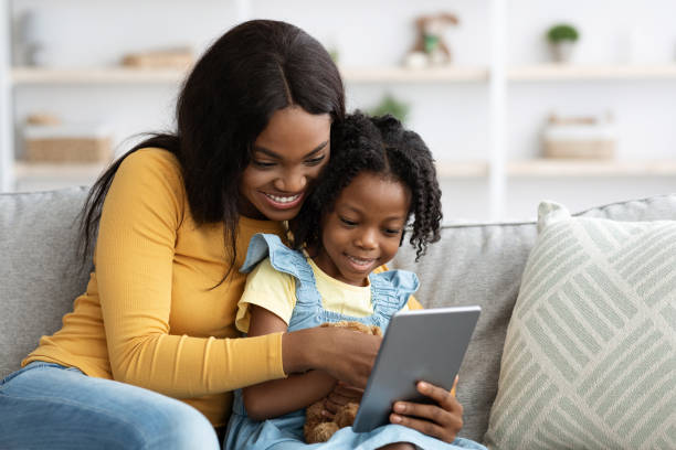 istock Technologies For Leisure. Happy Black Mother And Little Daughter Using Digital Tablet 1371965949