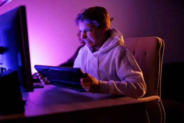 Kids playing team multiplayer video games using desktop PC. The boy is very angry and is about to smash the keyboard.
Canon R5